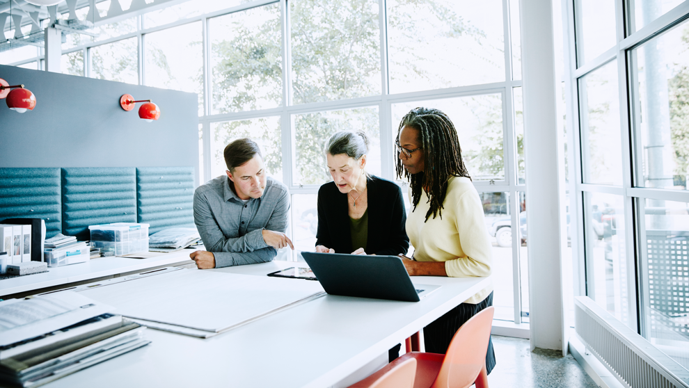 Three people reviewing a tablet